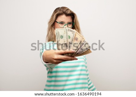 young latin pretty woman  against flat wall with dollar banknotes