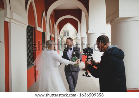 Wedding photographer taking pictures of the bride and groom in a gallery