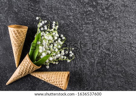 Ice cream cone with lilies of the valley. Top view. Copy space. Spring flowers concept.
