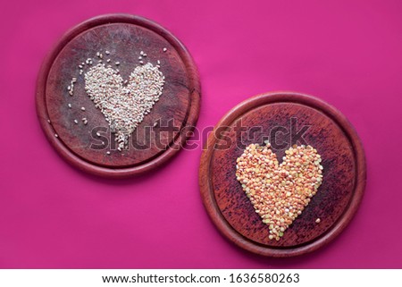 saint valentine's day. healthy food. heart.  groats on the cooking board. cutting board. red background. spices. healthy food