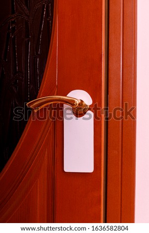 Do not disturb sign at the door. Empty label or flyer on a door handle for your text.
