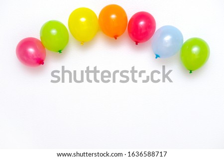 Colorful balloons on white wall or table top view. Festive or party background. Flat lay style. Copyspace for text. Birthday greeting card