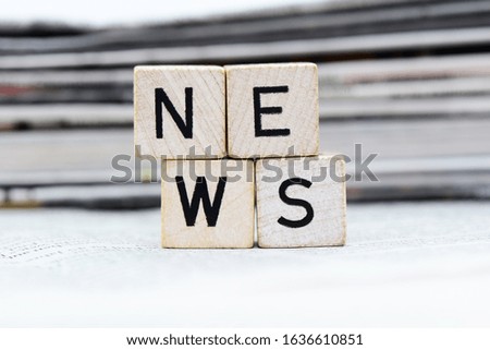 Wooden cubes with letters and newspapers