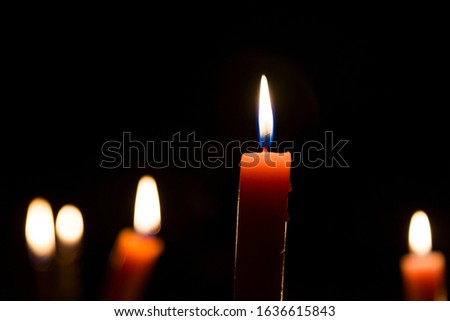 A lot of wax candles on black background.