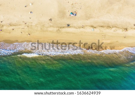 Aerial top view of beach with yellow sand and azure sea water, copy space.