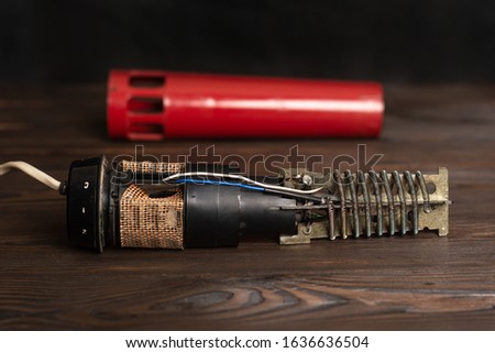 disassembled old hair dryer. In the background is a red outer hair dryer cover. selective focus Royalty-Free Stock Photo #1636636504
