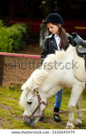Portrait of little girl with her pony