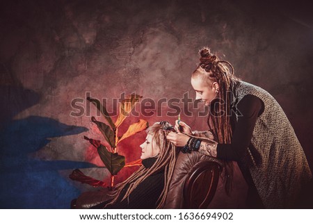 Process of dreadlocks making - female master is working on girl's hair.