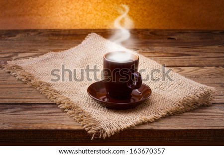 Cup of warm coffee and saucer on  wooden table. Free space for your text
