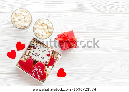 Valentine's Day. A gift for a loved one. 
Gingerbread cookies in a gift box. White wooden background top view, mockup 