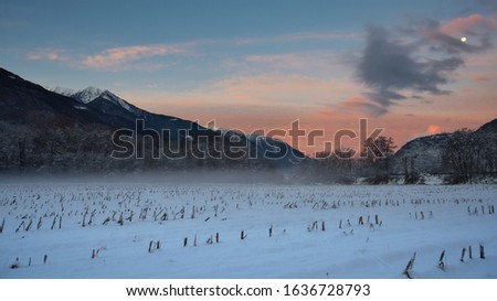 Picture of a winter sunset over a field in the Alps.