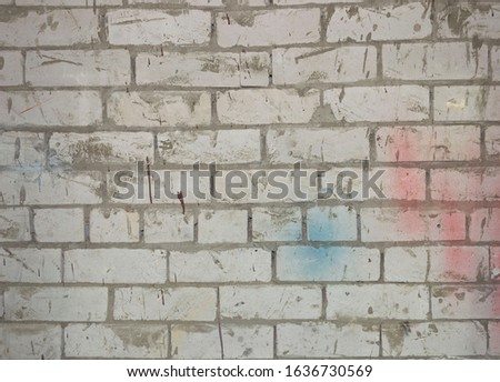 White brick wall with blue and red spot. warehouse background