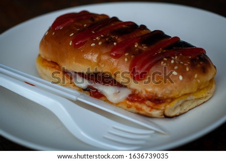 picture of sandwich on plate with plastic knife and fork