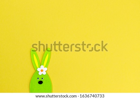 Easter background with decorative green bunny on yellow paper, minimal design, copy space, text place