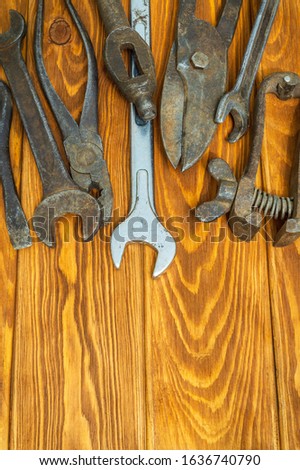 Many rusty old tools stacked after work on vintage wooden boards vertical orientation