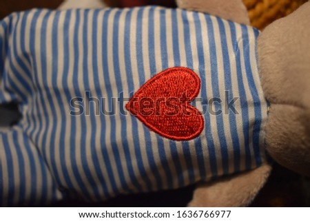 sewn heart on soft teddy bear's striped chest