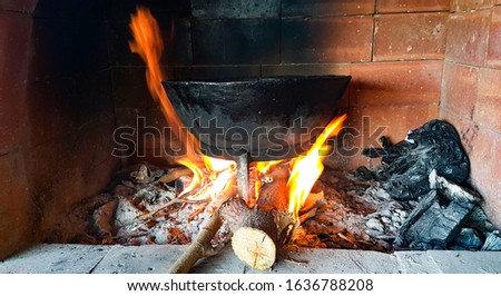Pot of soup on the burning wood. The fire in the old traditional village oven.
