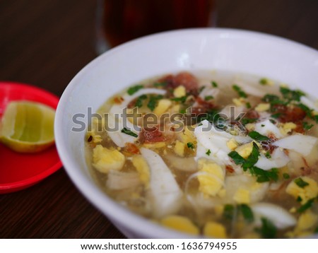 Indonesian chicken soto or soto ayam served on white bowl. Soto is a traditional Indonesian soup mainly composed of broth, chicken and vegetables.