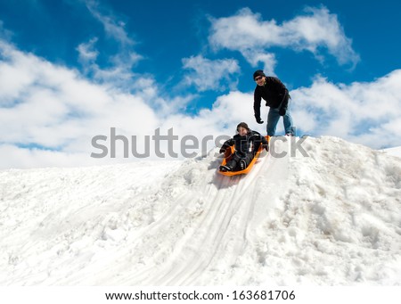 Boy and dad sledding in winter