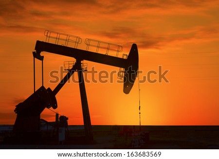 Oil pump oil rig in the sunset background for design