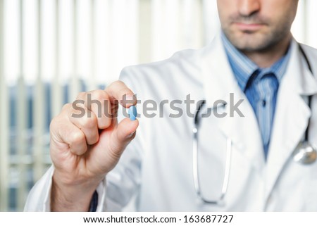 Doctor holding a blue pill.
