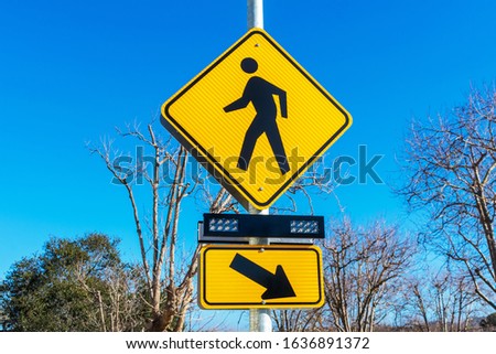 Pedestrian crossing sign with flashing lights. Crosswalk beacon provides advance notice of pedestrian activity for drivers.