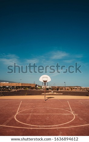 red basketball court and a big blue sky