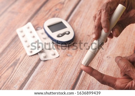 senior women hand measuring diabetic on table 