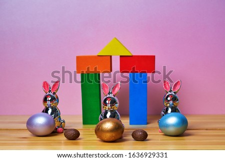 Happy Easter. Toy hares next to Easter eggs.