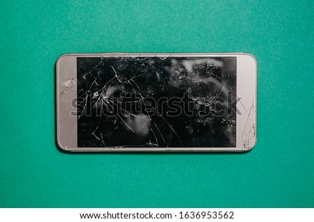 broken smartphone screen. Three-dimensional photo of broken equipment on a single-color blue mint background, top view