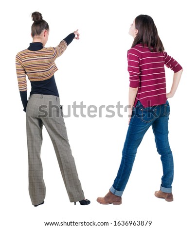 Back view of two pointing young girl in sweater. Rear view people collection. backside view of person. beautiful woman friends showing gesture. Rear view. Isolated over white background.