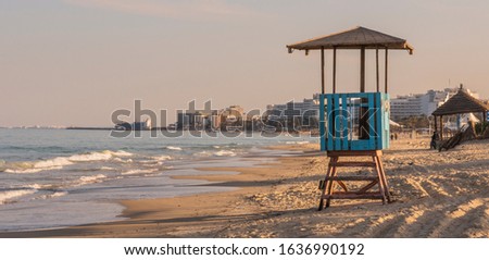Lookout tower on the sand with the coastline behind