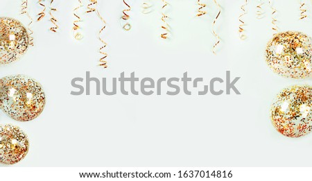 Gold serpentine and balloons with colorful confetti on light background, banner. Holiday decoration for parties, birthday, greeting card with copy space