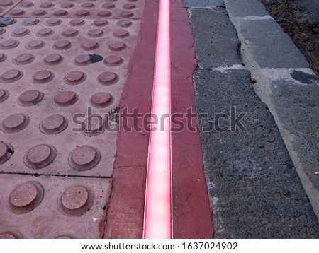 Traffic sign for pedestrians. LED strip on the pedestrian road. Braille Blocks in the pedestrian guiding the blinds walks