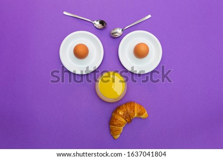 Fun breakfast concept with abstract angry grumpy human face made of breakfast items on purple background