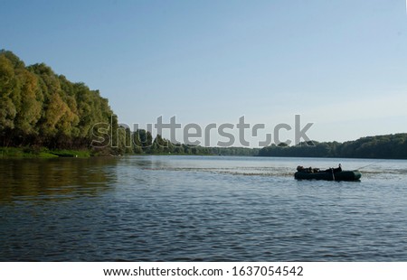 fisherman sleeps in a boat on a river near the shore. Beautiful dawn on the lake. Fishing. 
Fish does not bite! Angler enjoys beautiful, golden, foggy morning fishing on the lake. Autumn morning on 