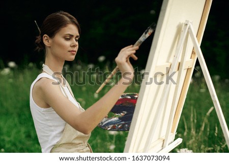 young woman draws in a forest glade
