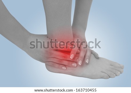 Acute pain in a woman ankle. Concept photo with blue skin with read spot indicating pain.