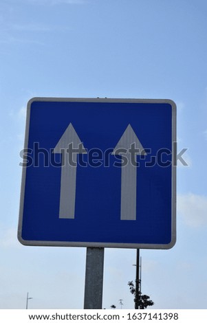 road sign white arrow on a blue background