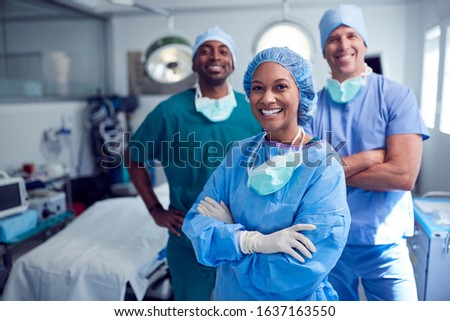 Portrait Of Multi-Cultural Surgical Team Standing In Hospital Operating Theater Royalty-Free Stock Photo #1637163550