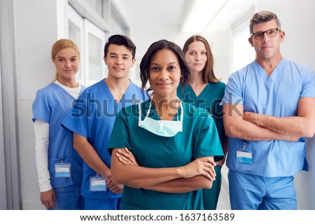 Portrait Of Multi-Cultural Medical Team Standing In Hospital Corridor Royalty-Free Stock Photo #1637163589