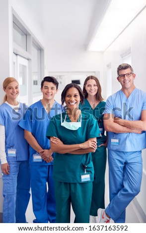 Portrait Of Smiling Multi-Cultural Medical Team Standing In Hospital Corridor