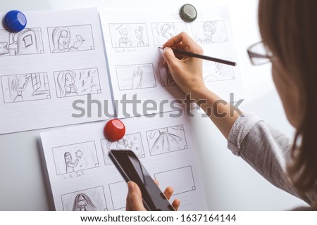 Woman draws a storyboard for an animated film on a white board. Royalty-Free Stock Photo #1637164144