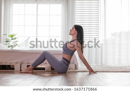 Happy Athletic Asian woman practice yoga stretching pose for stretching muscle for warm up with meditation smile after wake up in the morning Feeling so comfortable and relax,Healthcare Concept