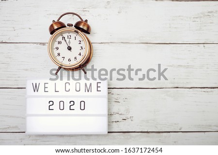 Welcome 2020 text in light box with space copy on wooden background