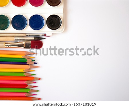 Watercolor paints, brushes and set pencils top view. Creative artistic mockup with copyspace