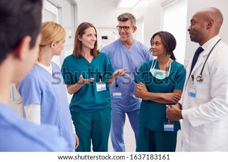 Multi-Cultural Medical Team Having Meeting In Hospital Corridor Royalty-Free Stock Photo #1637183161