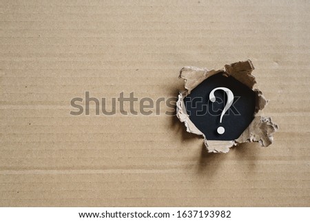 Torned corrugated box revealing question mark. Concept of mystery and uncertainty