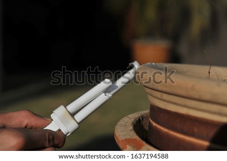 broken light bulb beside a vase