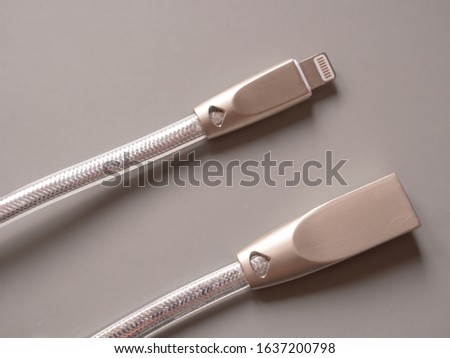 Silver wire for charging smartphone on a white background. copy space for text